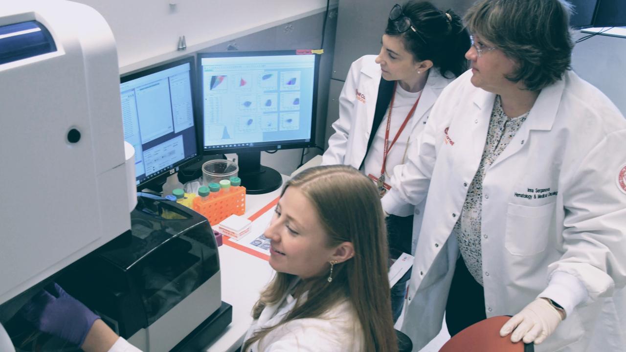 Zappasodi Lab team members looking at equipment and computers